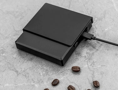 0.1g High Precision Drip Espresso Scale being charged with Type-C cable connected on the side, showing fast and convenient charging.